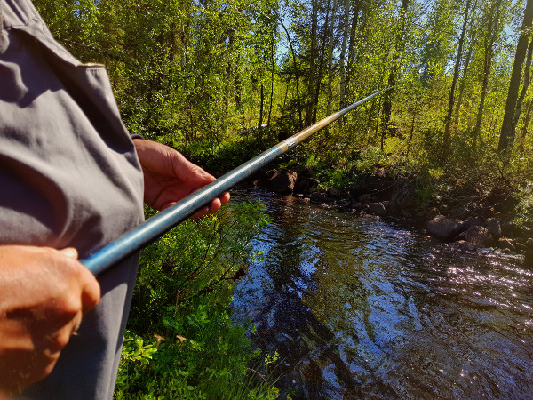 Fisker med meitestang i en bekk